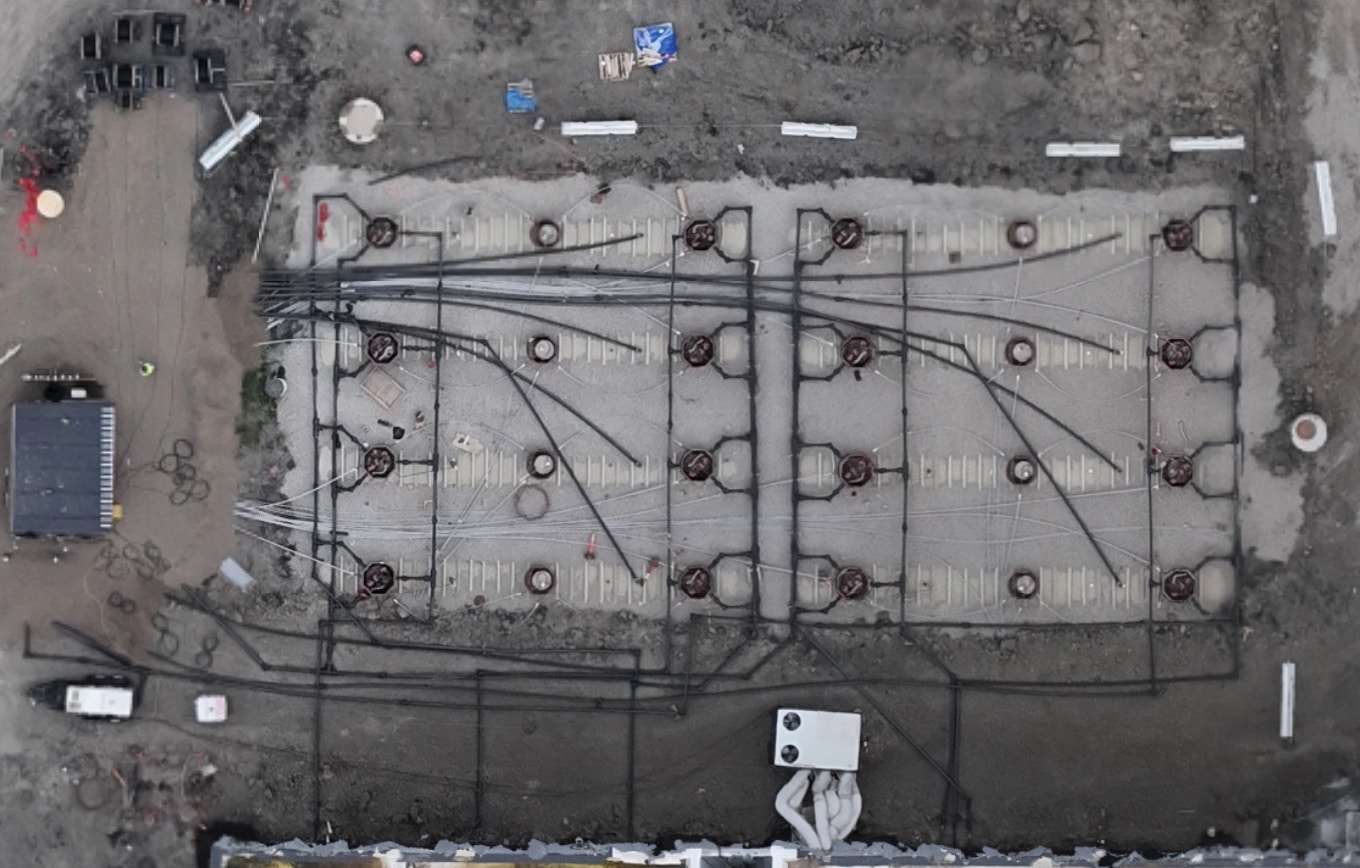 Aerial view of a data center generator fuel tank field with backfilled tanks and piping runs